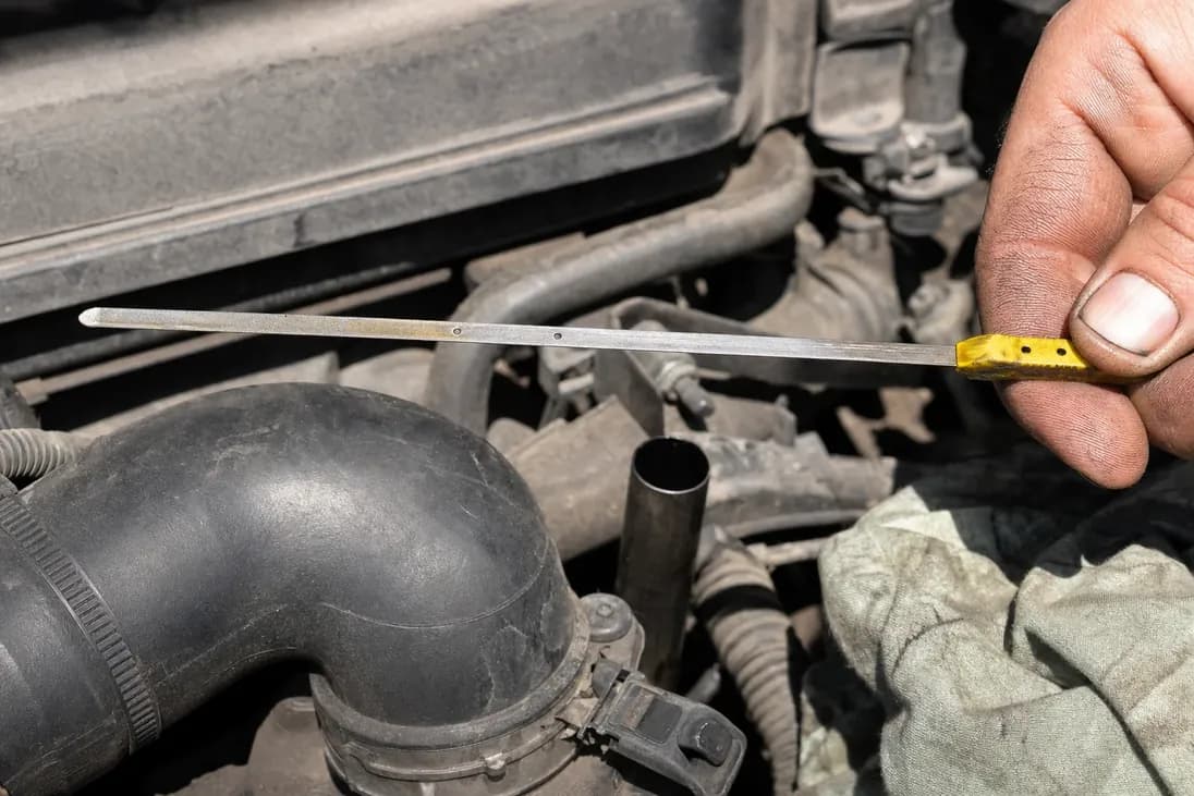 Engine oil dipstick drawn out of the engine to read the level