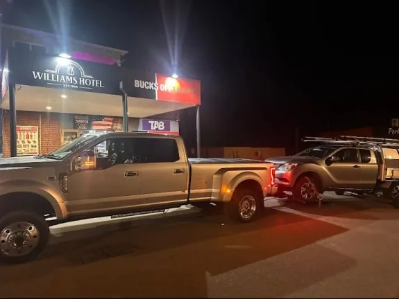 Silver Mazda BT-50 ute with a service body hooked up for towing at night outside the Williams Hotel on Albany Highway