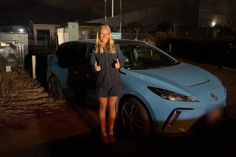Chelsea gives a thumbs up beside her blue MG4 electric car after the tow to Bassendean