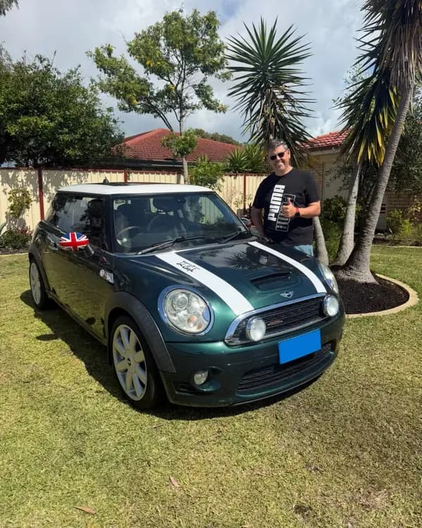 Eddie gives a thumbs up beside his green MINI Cooper S after the tow to Cooloongup