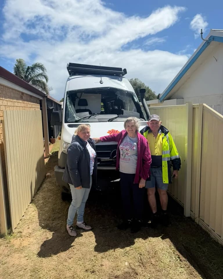 Three of the family stand in front of the white Sprinter van after it was set down in their side yard in Waikiki