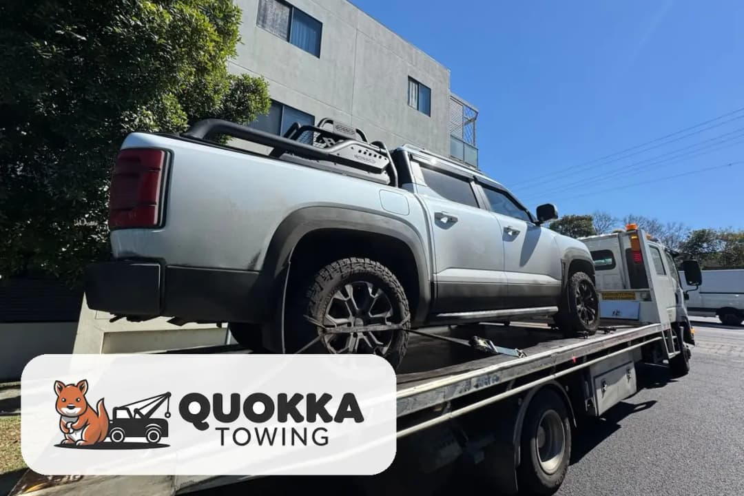 A ute strapped down on a Quokka Towing tilt tray on a Perth street