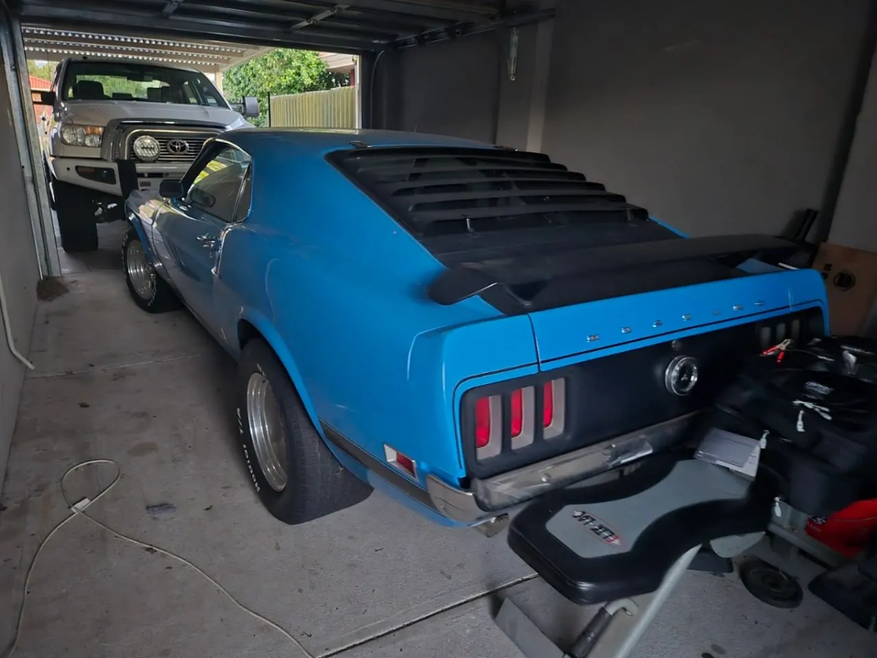Blue classic Ford Mustang fastback in a home garage