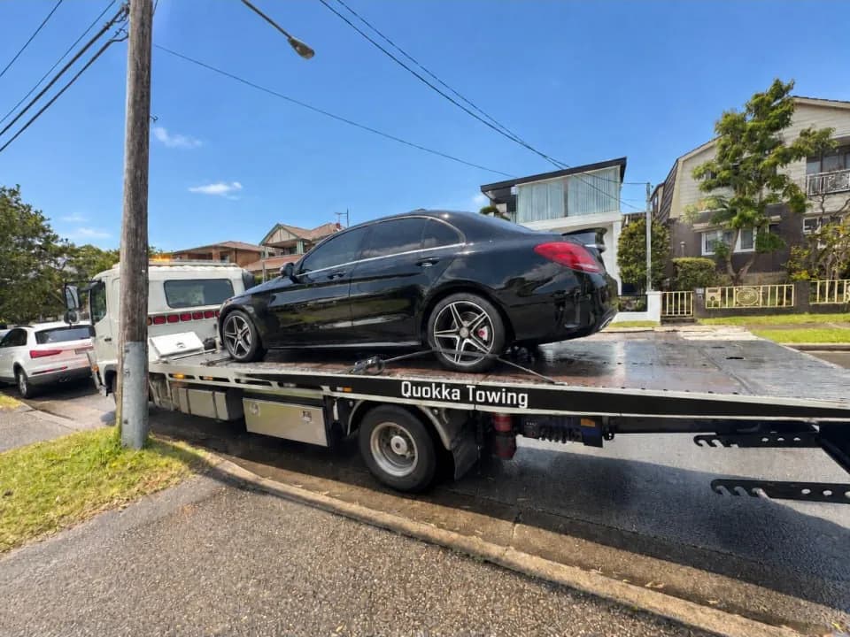 Black Mercedes sedan carried on a Quokka Towing tilt tray