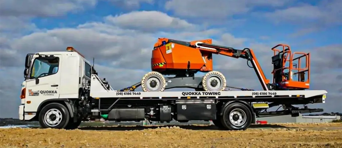 Quokka Towing tilt tray carrying an orange boom lift
