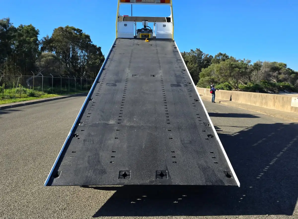 A Quokka Towing tilt tray with its deck tilted down to the road, ready to load
