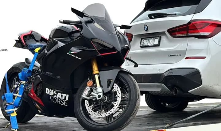 Ducati sports motorcycle strapped down on a Quokka Towing tilt tray beside a white SUV