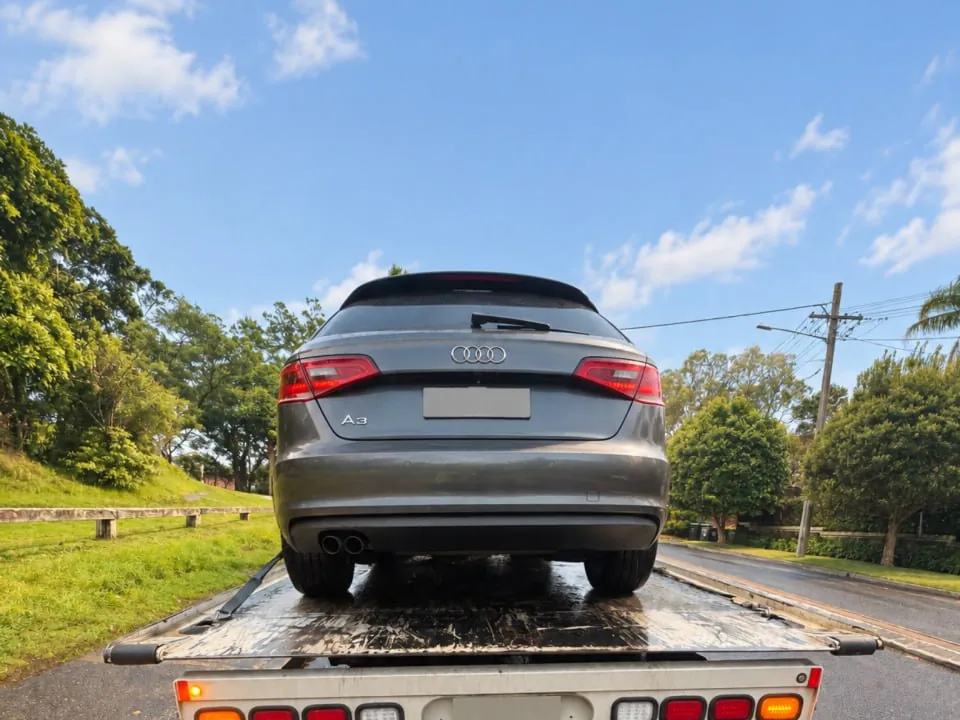Quokka Towing tilt tray with a grey Audi hatchback strapped down, seen from behind