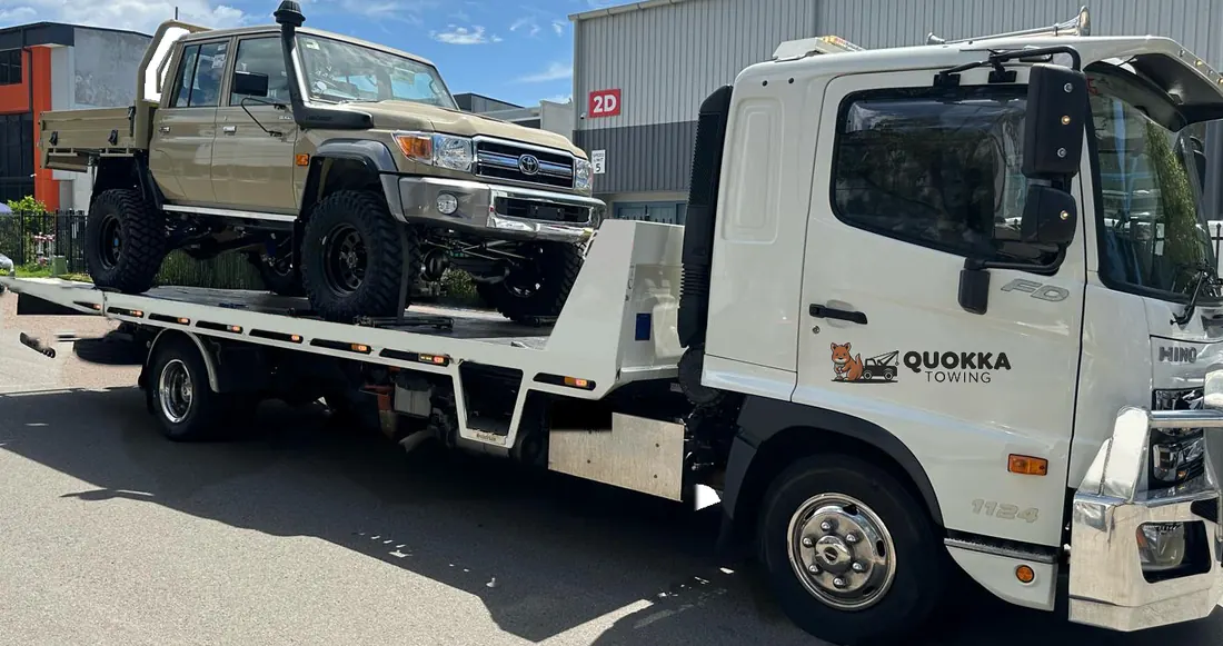 Lifted LandCruiser ute strapped down on a Quokka Towing tilt tray