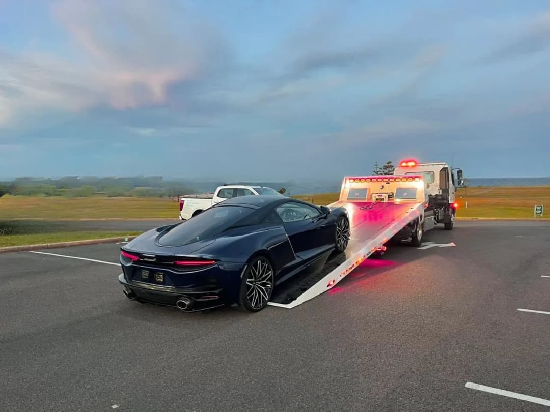 A sports car being loaded onto a Quokka Towing tilt tray
