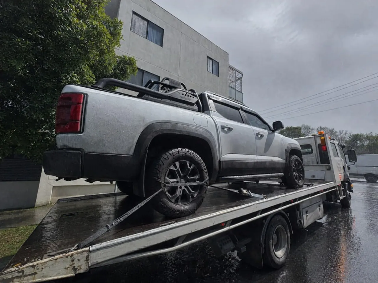 Quokka Towing tilt tray carrying a silver dual-cab ute in the rain