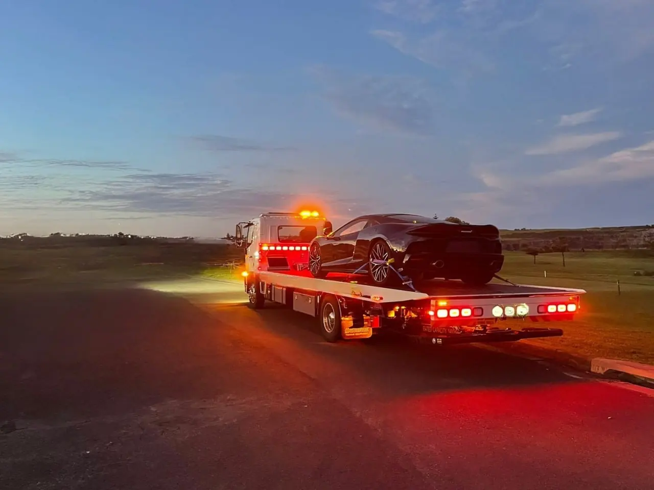Quokka Towing tilt tray carrying a sports car at dusk