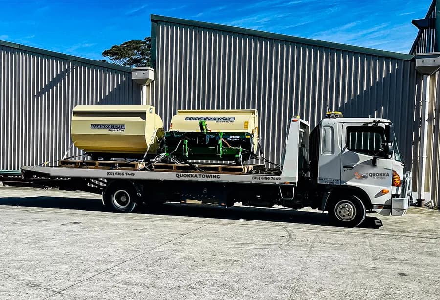 Two farm machines on pallets on a Quokka Towing tilt tray