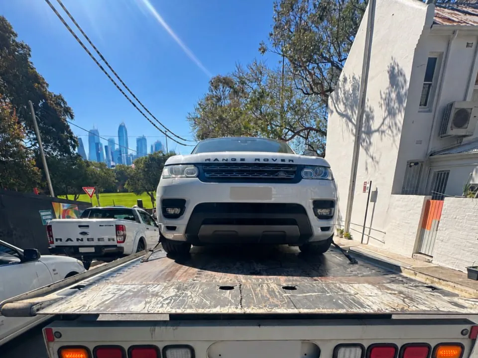 White Range Rover strapped onto a Quokka Towing tilt tray, seen from behind