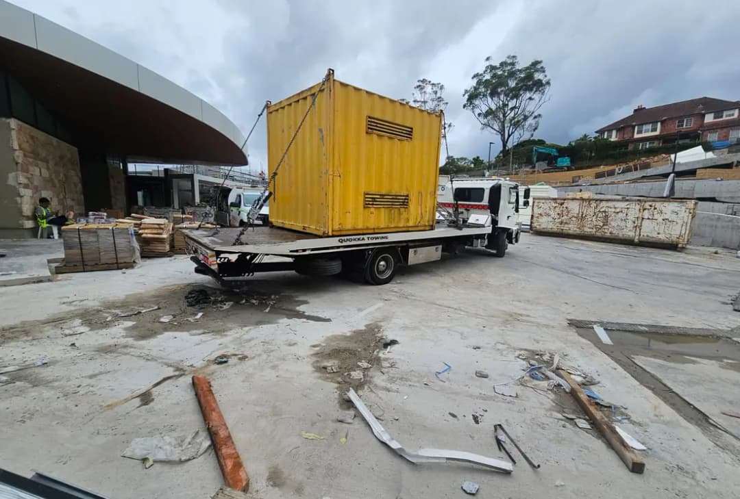 Yellow shipping container chained down on a Quokka Towing tilt tray