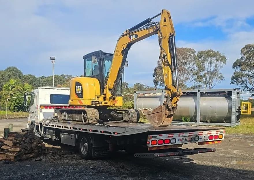 Quokka Towing tilt tray carrying a yellow mini excavator