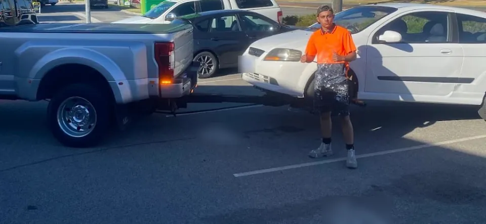 Quokka Towing ute towing a white hatchback out of a car park on its wheel lift