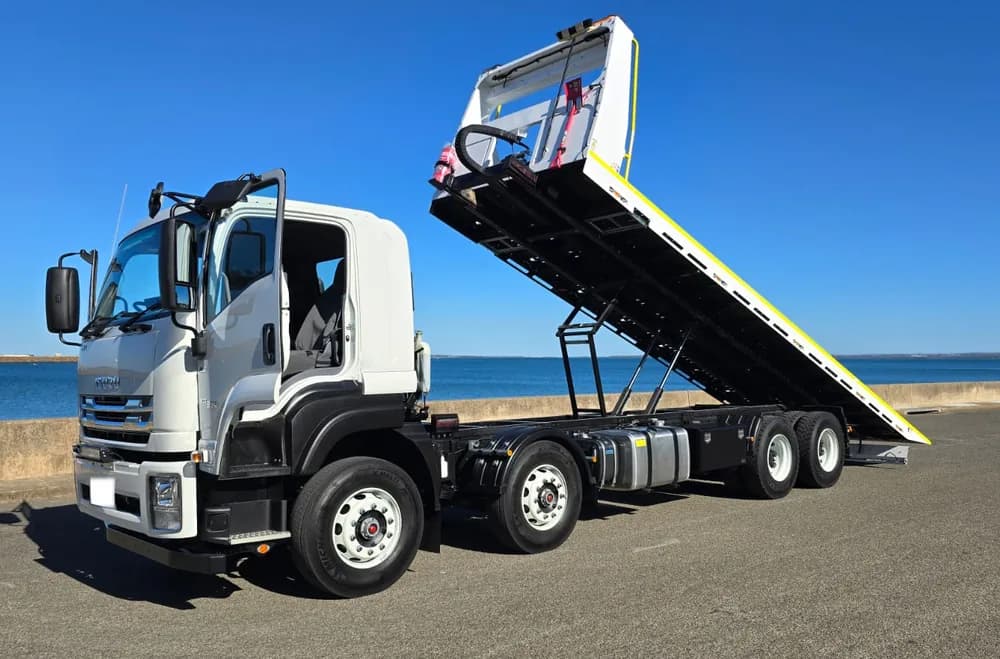 Eight-wheel tilt tray truck with its deck raised to load