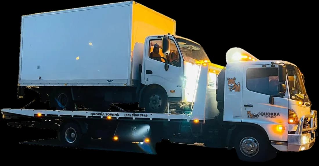 White box truck carried on a Quokka Towing tilt tray at night
